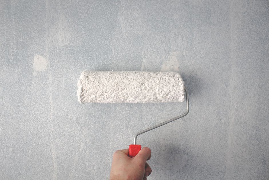 Rolling the first coat on an interior wall